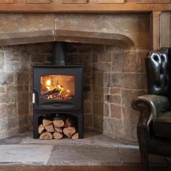 Charnwood C-Seven in Black on a Store Stand - Lifestyle Image in a Traditional Brick Fireplace