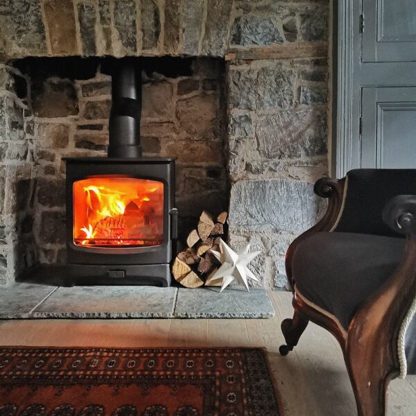 Charnwood Aire 7 Low in Black - Wood-Burning Stove Lifestyle Image in Traditional Fireplace