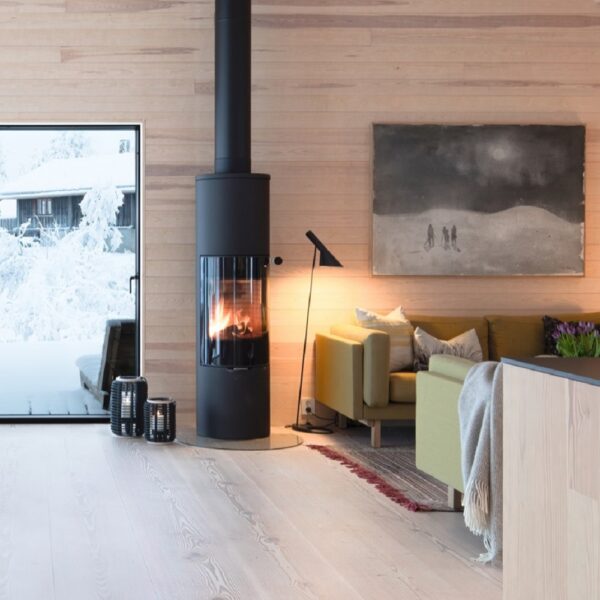 RAIS Viva L 160 Wood-Burning Stove - Lifestyle Image in Black with Glass Door and Patina Oak Handle