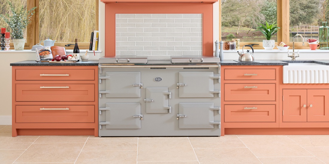 Everhot 150+ Elecrtic Range Cooker in Goose Grey - Lifestyle image in a vibrant orange kitchen setting.