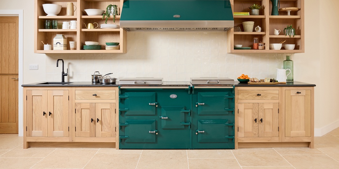 Everhot 160i Electric Range Cooker in Forest Green. Landscape lifestyle image in a wooden showroom kitchen setting.