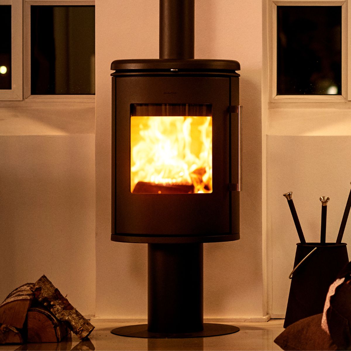 Morso 6848 mounted onto a wall at night time with flames